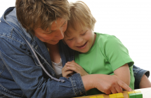 Woman holding child and pointing to bricks